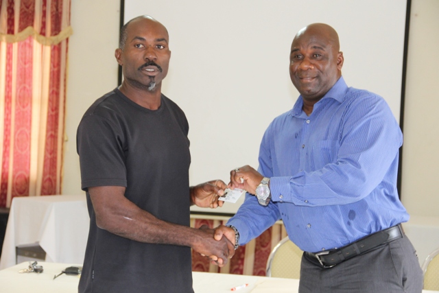 Minister of Agriculture Hon. Alexis Jeffers (r) presents a Farmers Identification Card issued by the Department of Agriculture to Ellis Philip, a farmer at a ceremony to launch the Farmer’s Identification Card from the Department of Agriculture at the Red Cross conference room on May 24, 2016